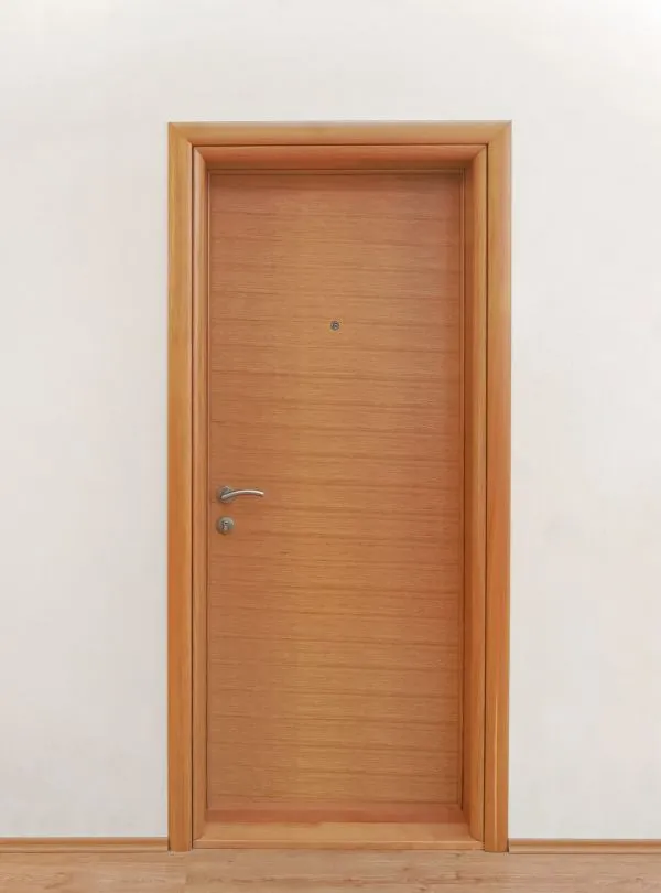 Puerta interior de madera con acabado natural y tirador metálico